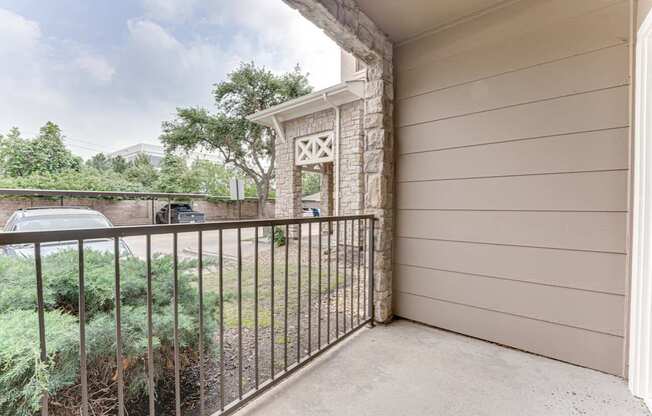 A balcony with a metal railing and a stone pillar.