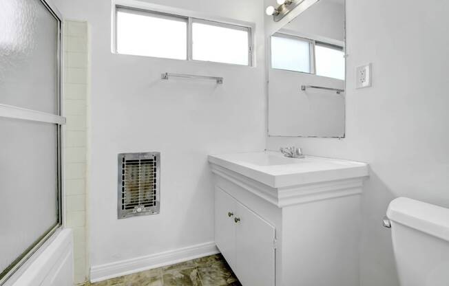 a large white bathroom with a shower and a mirror