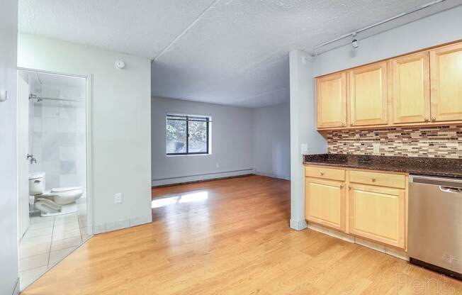 A kitchen with wooden cabinets and a stainless steel dishwasher.