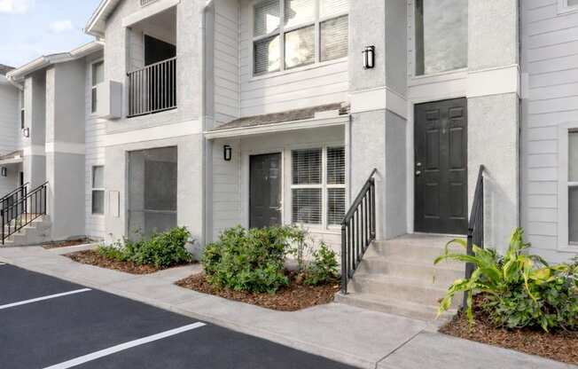 A row of townhouses with a parking lot in front.