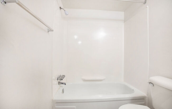 a white bathroom with a tub and a toilet