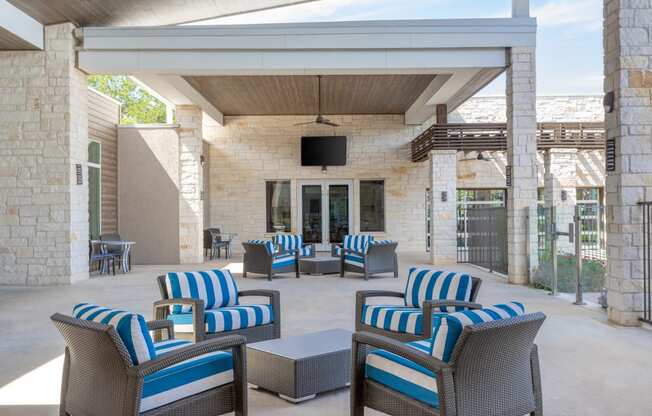 an outdoor patio with blue and white chairs and a television