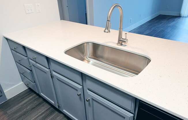 a kitchen counter with a sink and a faucet