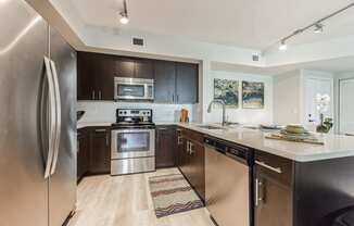 an open kitchen with stainless steel appliances and a counter top