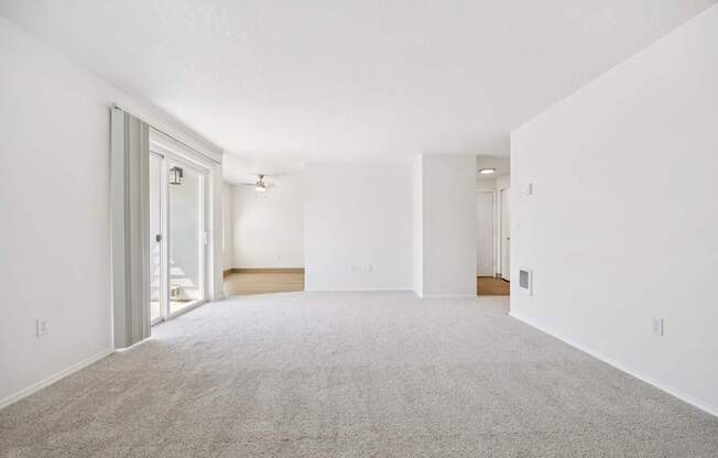 A large, empty room with a carpeted floor and white walls.