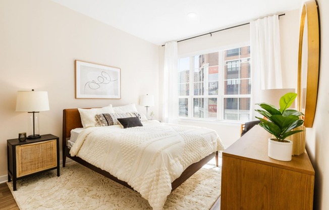 a bedroom with a bed and a large window at One Ten Apartments, New Jersey, 07310