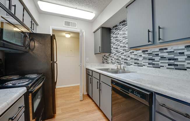 an empty kitchen with a sink and a refrigerator