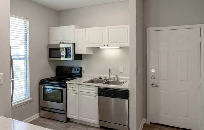 a kitchen with stainless steel appliances and white cabinets