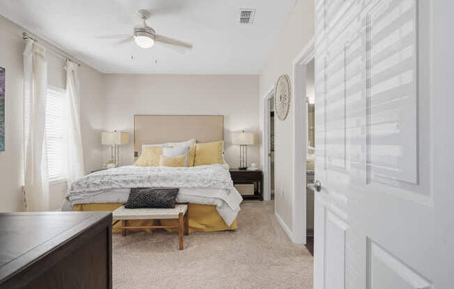 A bedroom with a bed, nightstands, and a ceiling fan.