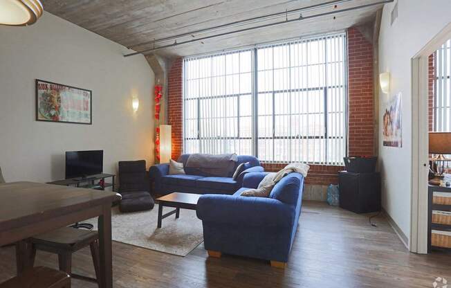 a living room with a large window and a blue couch