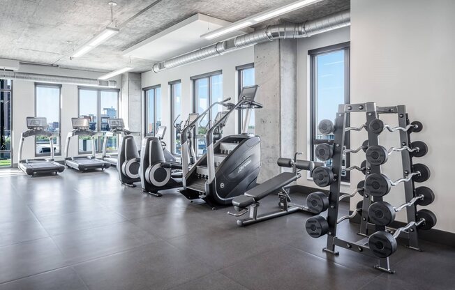 Fitness center with treadmills, stairmaster, benches, elliptical, and barbells