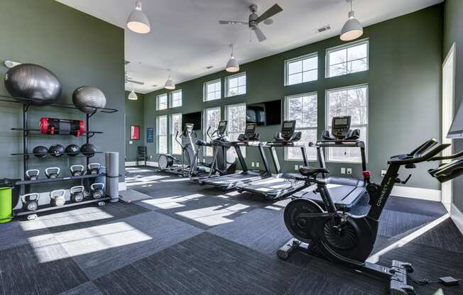 a gym with weights and cardio equipment at the belgard apartments