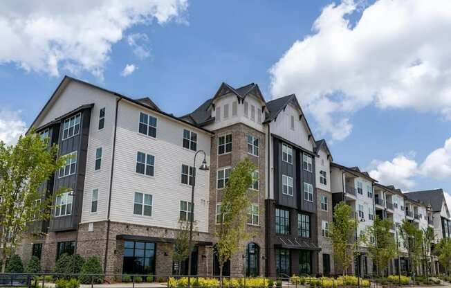a large apartment building with a cloudy blue sky in the background