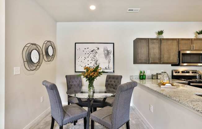 a dining room with a table and chairs and a kitchen  at Aventura at Hawk Ridge, Lake St Louis, 63367