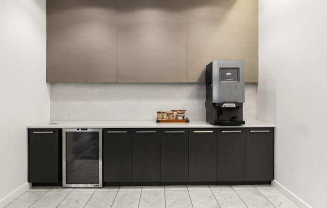 a kitchen with a coffee machine and black cabinets