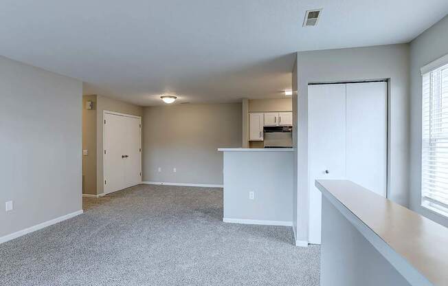 A spacious room with a kitchenette and a window.