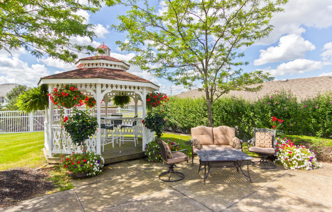 a gazebo on a patio with chairs and a table