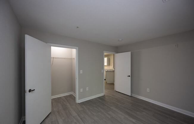 an empty living room with a door to a closet and a bathroom at Magnolia Pointe Apartments in Duluth, GA