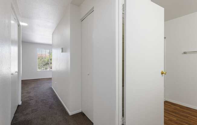 an empty room with white walls and a door to a closet