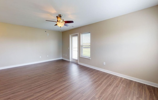 Enlarged living room with hard surface flooring and a ceiling fan