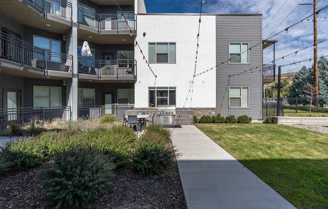 an exterior view of an apartment building with a sidewalk and grass