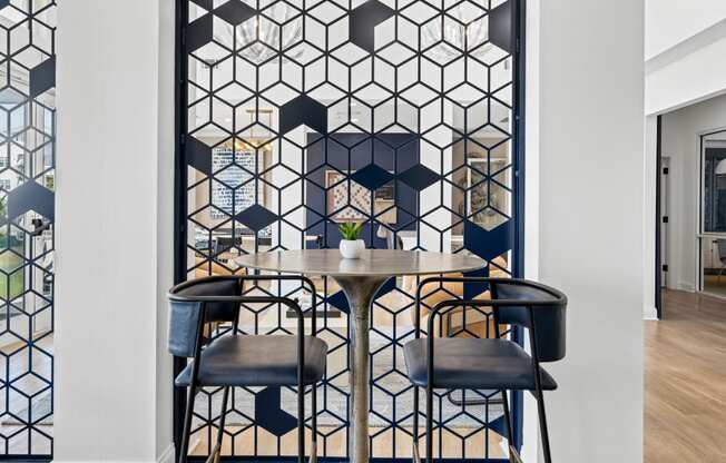 resident lounge area with table and chairs and a geometric pattern on the wall