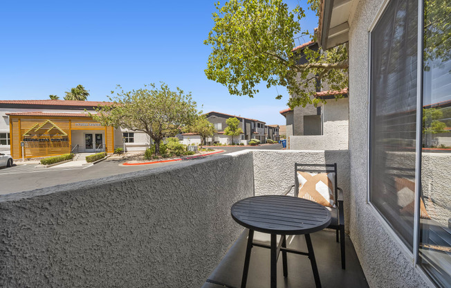 a patio with a table and a chair on a balcony