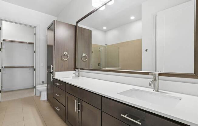 A bathroom with a sink, mirror, and toilet.