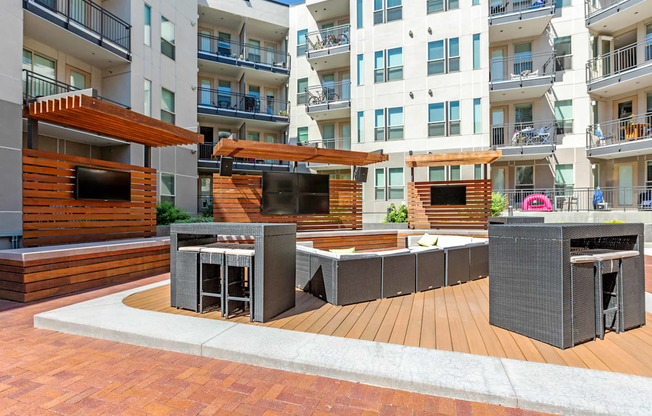 A modern outdoor seating area with a wooden deck and a television.