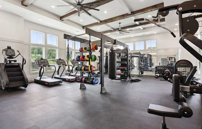 A spacious gym with a variety of equipment including treadmills, weights, and a bench press.
