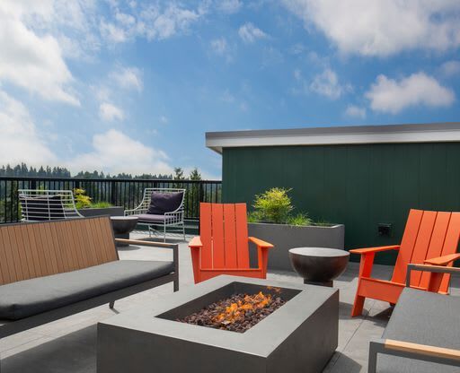 a patio with chairs and a fire pit