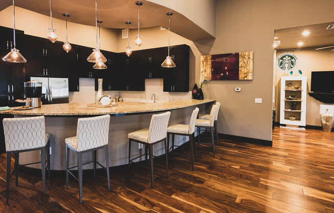 a kitchen and dining room with a bar and chairs