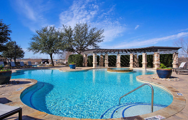 A swimming pool with a blue tinted water and a metal ladder.
