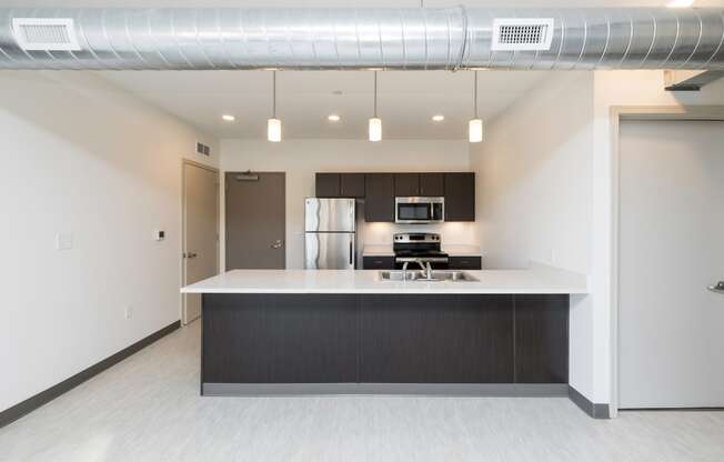 Modern open-concept kitchen and living area with stainless steel appliances.