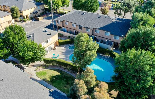 an aerial view of a house with a swimming pool and bridge