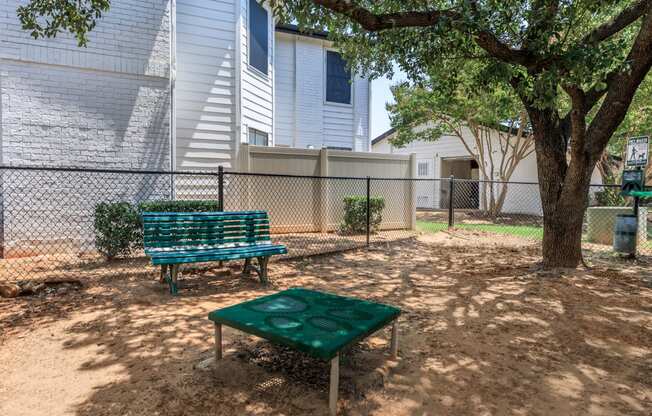 a park bench and picnic table in front of an apartment building