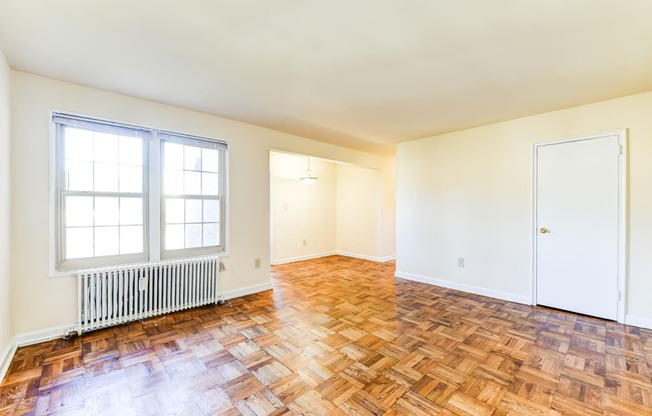 vacant living area with hardwood flooring and large windows at richman apartments in washington dc