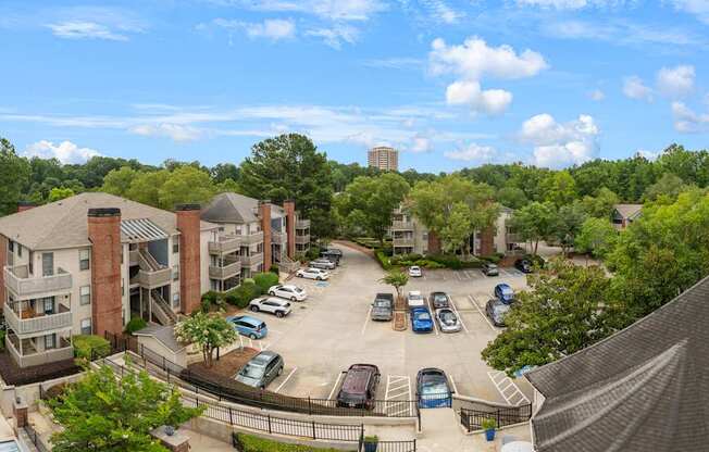 A view of a parking lot with cars and apartment buildings.