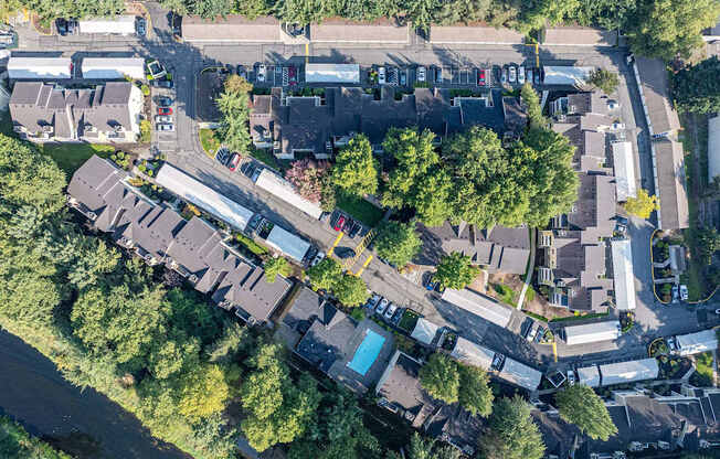 A bird's eye view of a residential area with houses, roads, and a river.