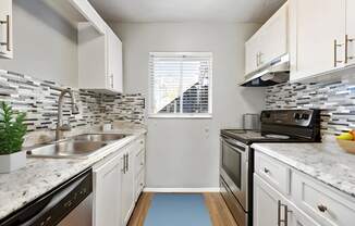 a kitchen with white cabinets and granite counter tops and a sink