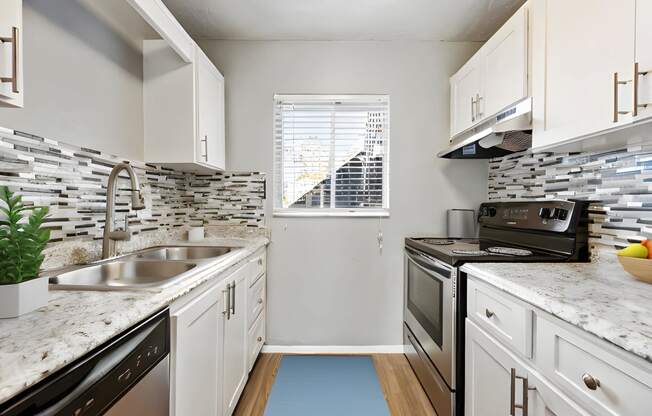 a kitchen with white cabinets and granite counter tops and a sink