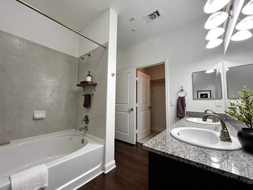 A bathroom with a white tub and sink.