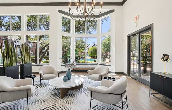 A living room with a chandelier, a sofa, a chair, a table, and a rug.