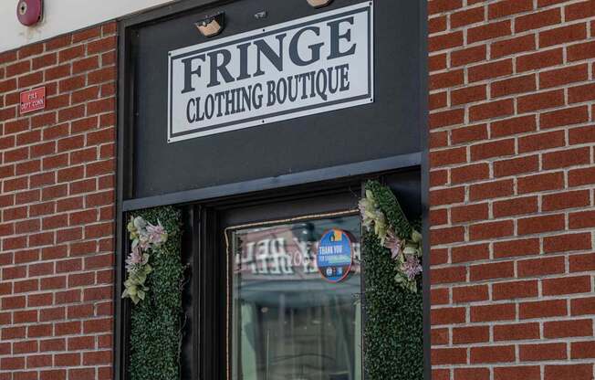 A storefront with a sign that says Fringe Clothing Boutique.