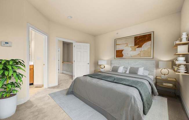 A bedroom with a large bed and a potted plant.