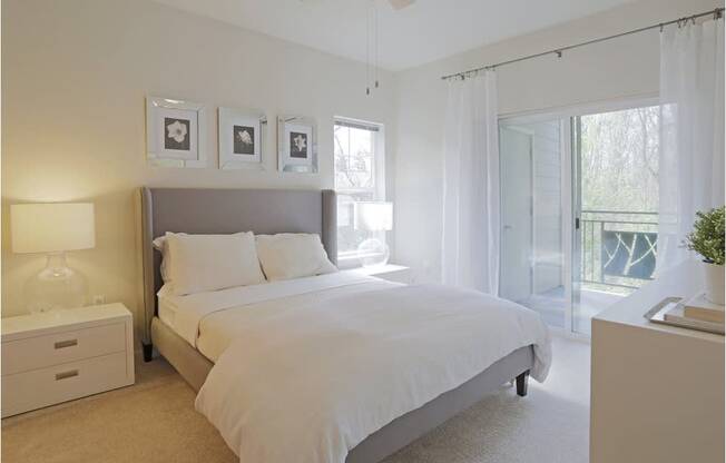 A bedroom with a large bed, a nightstand with a lamp, and a ceiling fan at Wilsonville Summit Apartments, Wilsonville , OR