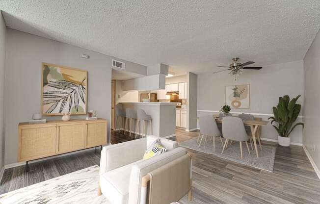 A living room with a white couch and a wooden floor.