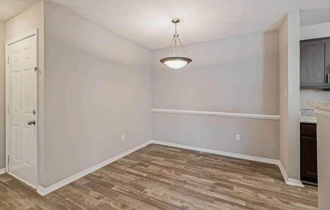 the living room and dining room of an empty home with wood flooring