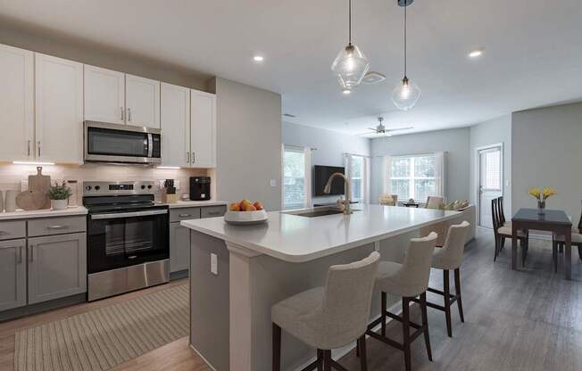 A modern kitchen with a large island and bar stools.