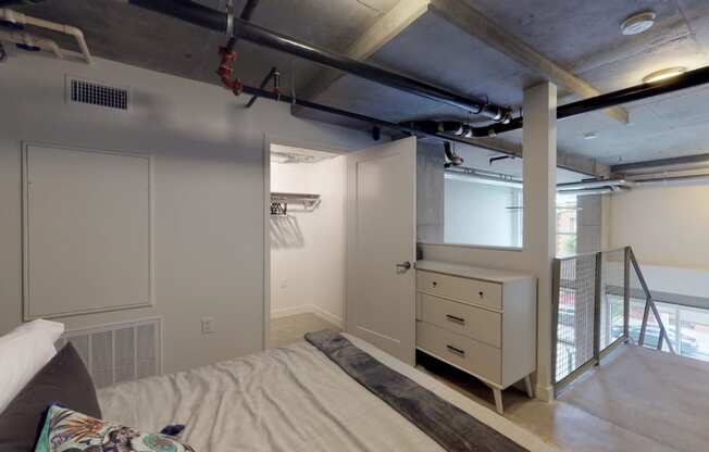 a bedroom with a bed and a closet and a stairwell